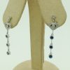 0.65 carat Sapphire with 0.12 carat Diamonds Drop Earrings with 18K gold hanging on carton ears