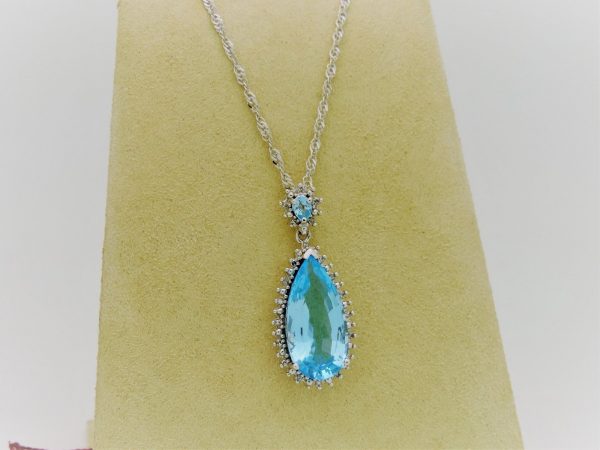 5.00 Ct Blue Topaz with 0.10 Ct Diamond Halo Pendant 14k Includes 14k Chain on a piece of carton