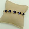Good Luck 18K Yellow Gold Evil Eye Bracelet Mariner Clasp on a pillow