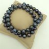 Elegant 12mm Black Tahitian Pearls w/ 14k White Gold Clasp on a pillow