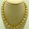 A side view of golden South Sea Pearls 16mm 18k Yellow gold Clasp w/ VS Diamonds accents on a fake neck