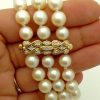 A woman holding 3 Row South Sea Cultured Pearls 8mm 18k Yellow Gold Clasp w/ VS Diamonds accents