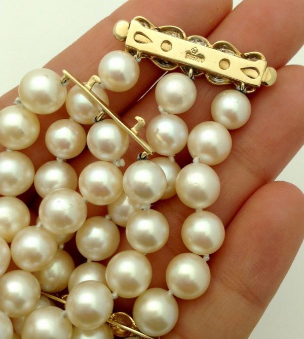 A woman holding 3 Row South Sea Cultured Pearls 8mm 18k Yellow Gold Clasp w/ VS Diamonds accents