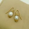 Two Short Drop South Sea Cultured 10mm Pearls w/ 14k Yellow Gold Rustic Accents on a pillow