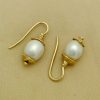 Two Short Drop South Sea Cultured 10mm Pearls w/ 14k Yellow Gold Rustic Accents on a pillow