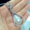A woman holding 18.7 Ct Mabe Pearl with 1.00 Ct Diamond 14k White Gold Pendant with 16" 14k White Gold Chain