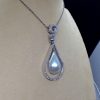 Side view of 18.7 Ct Mabe Pearl with 1.00 Ct Diamond 14k White Gold Pendant with 16" 14k White Gold Chain hanging on a fake neck