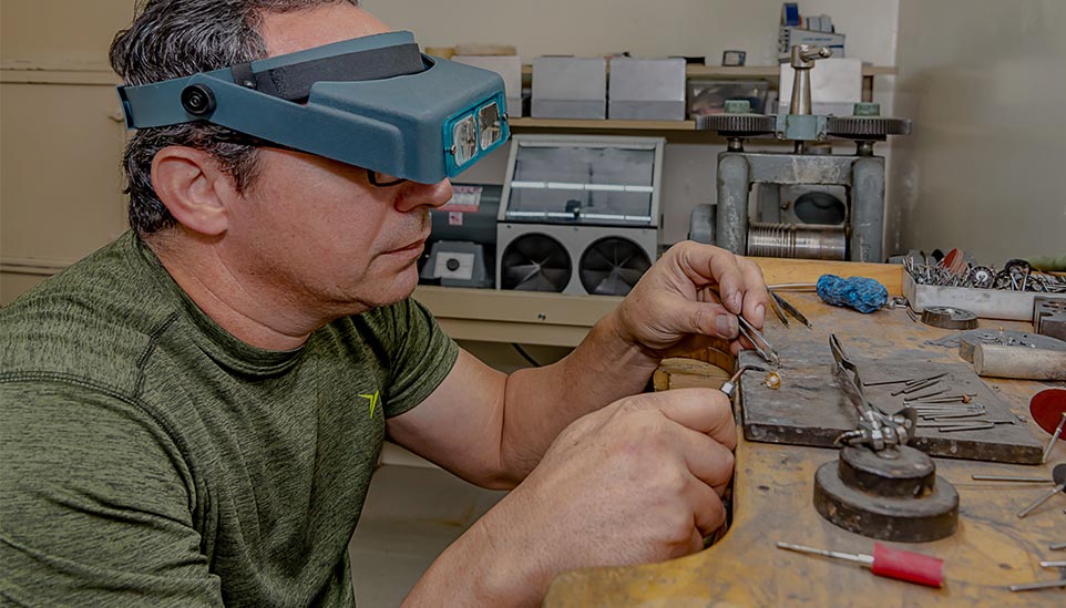 A man fixing jewelry with microscopic glasses