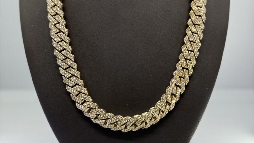 Sell gold in Aventura, FL with this thick Cuban chain gold necklace showcased on a bust at Koosh Jewelers.